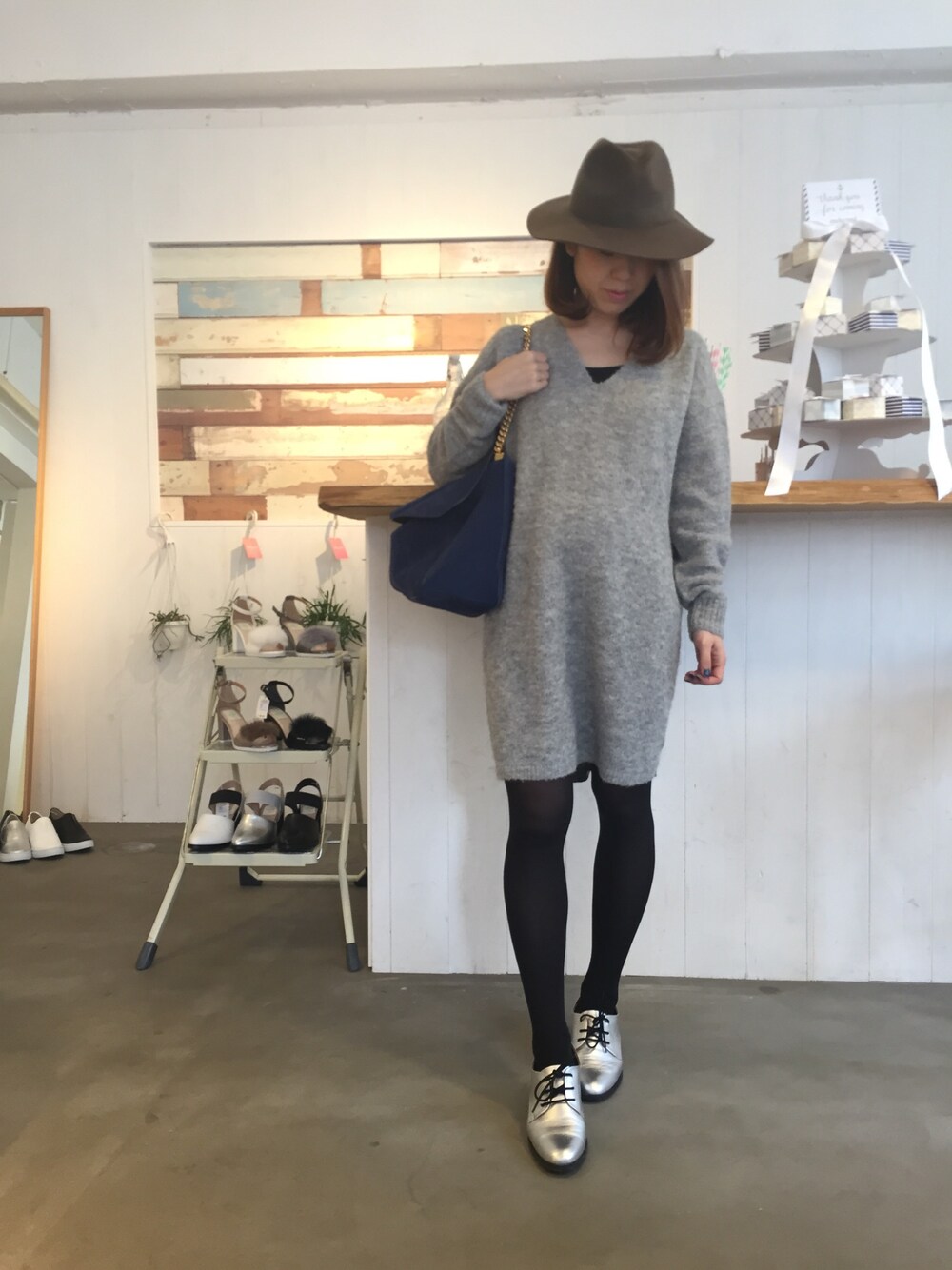 グレー系のワンピース、ブルー系のショルダーバッグ、シルバー系のドレスシューズを着用したレディースの秋コーディネートの1枚目の写真