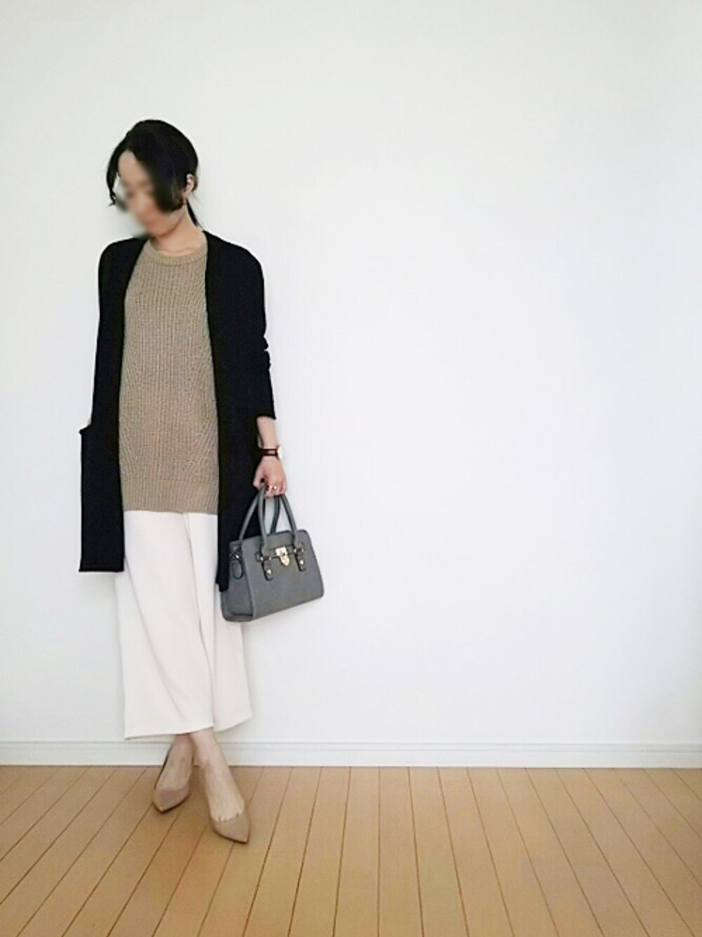 ベージュ系のベストを着用したレディースの春コーディネートの1枚目の写真