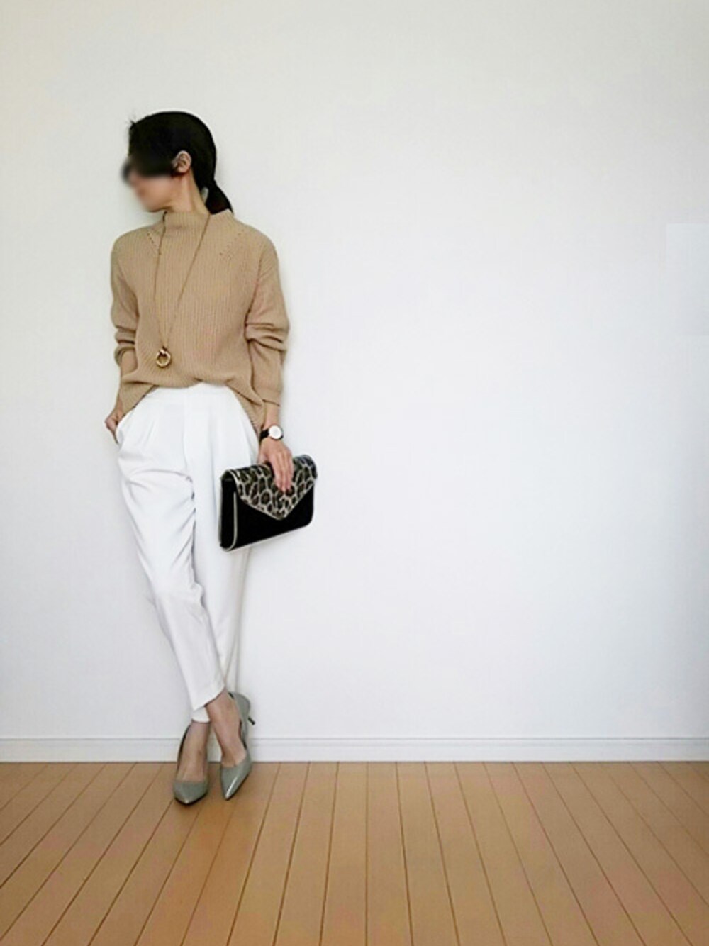 ベージュ系のニット/セーター、ブラック系のクラッチバッグ、ゴールド系のアナログ腕時計を着用したレディースの春コーディネートの1枚目の写真