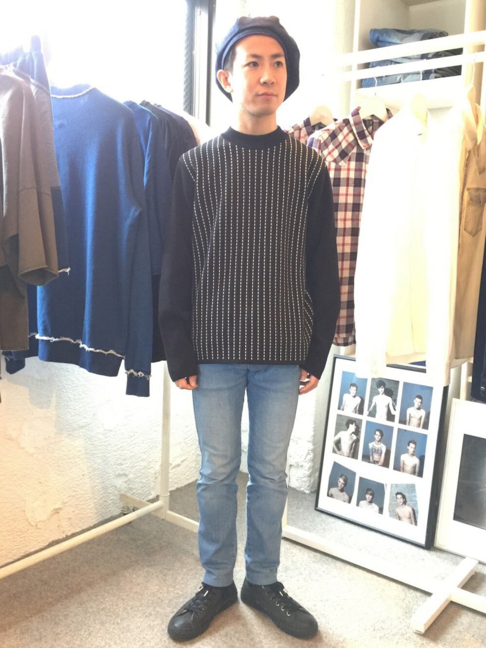 ブラック系のニット/セーター、ブルー系のデニムパンツ、ブラック系のスニーカーを着用したメンズの秋コーディネートの1枚目の写真