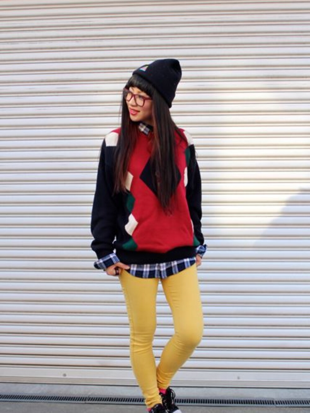 レッド系のニット/セーター、ブラック系のスニーカー、ブラック系のニットキャップ/ビーニーを着用したレディースの冬コーディネートの1枚目の写真