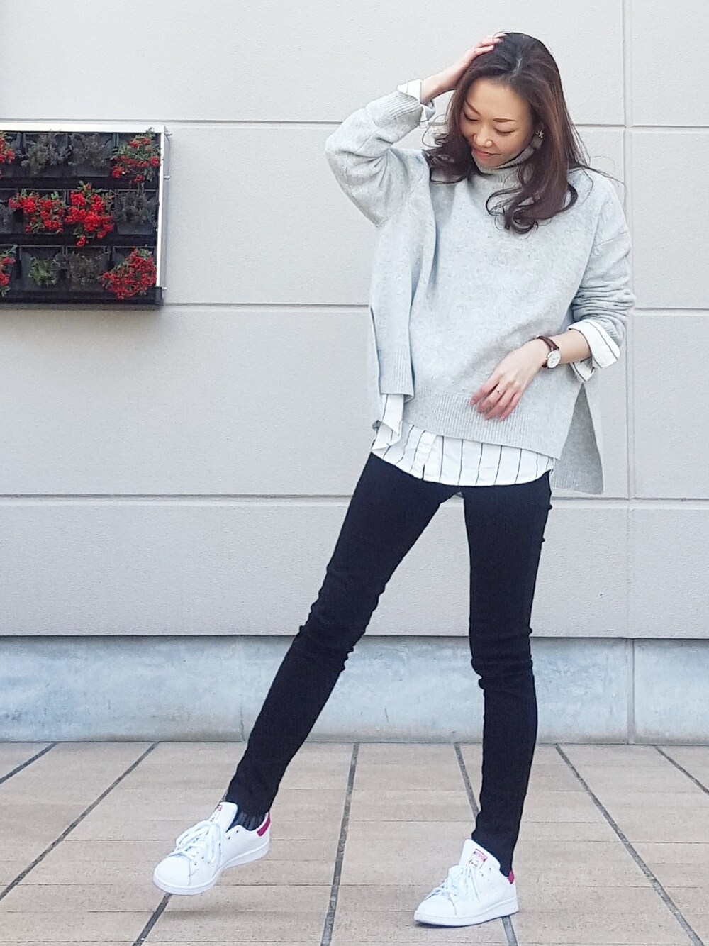 ブラック系のデニムパンツ、ホワイト系のシャツ/ブラウス、グレー系のニット/セーターを着用したレディースの冬コーディネートの1枚目の写真