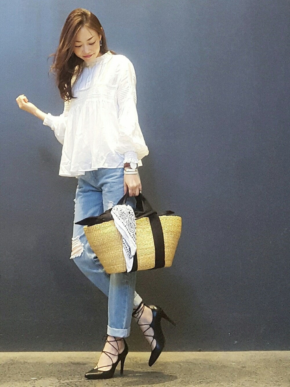 ブラック系のかごバッグ、ホワイト系のシャツ/ブラウス、ブルー系のデニムパンツを着用したレディースの春コーディネートの1枚目の写真