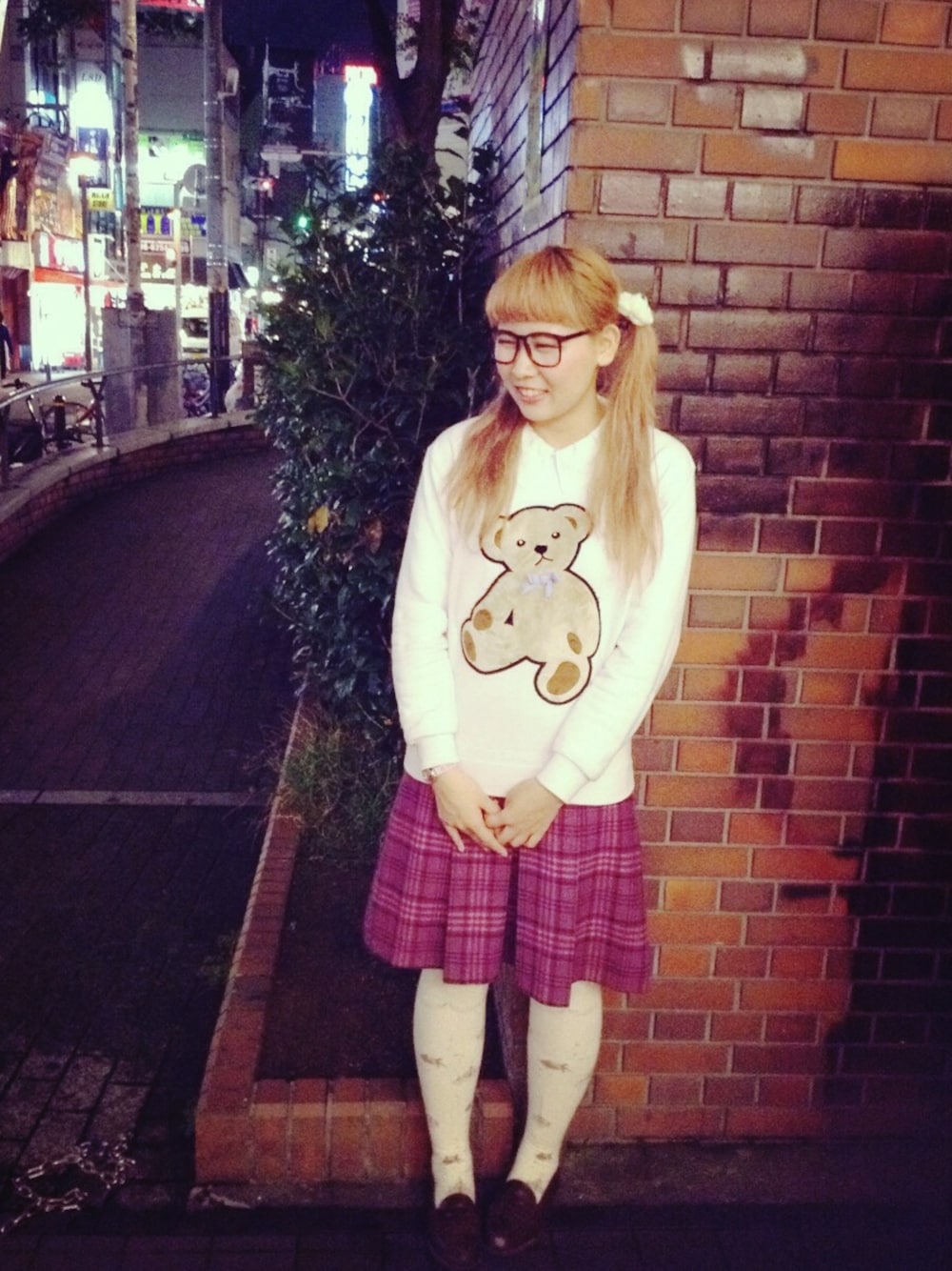 ピンク系のスカート、ピンク系のスウェット、ホワイト系のヘアゴムを着用したレディースの秋コーディネートの1枚目の写真