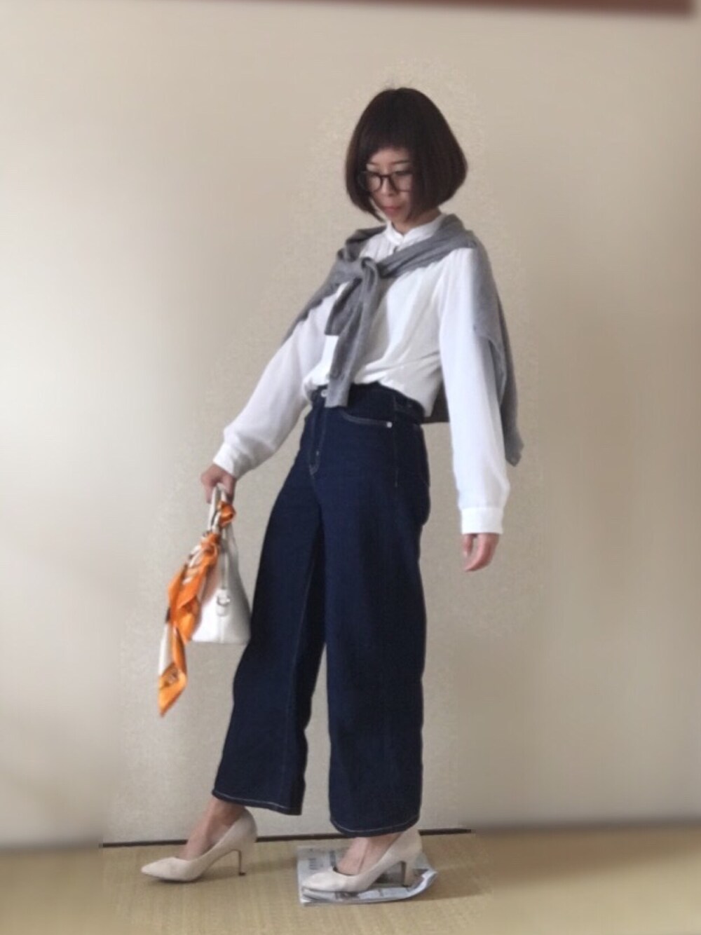 ブルー系のパンツ、ベージュ系のパンプス、グレー系のカーディガン/ボレロを着用したレディースの春コーディネートの1枚目の写真