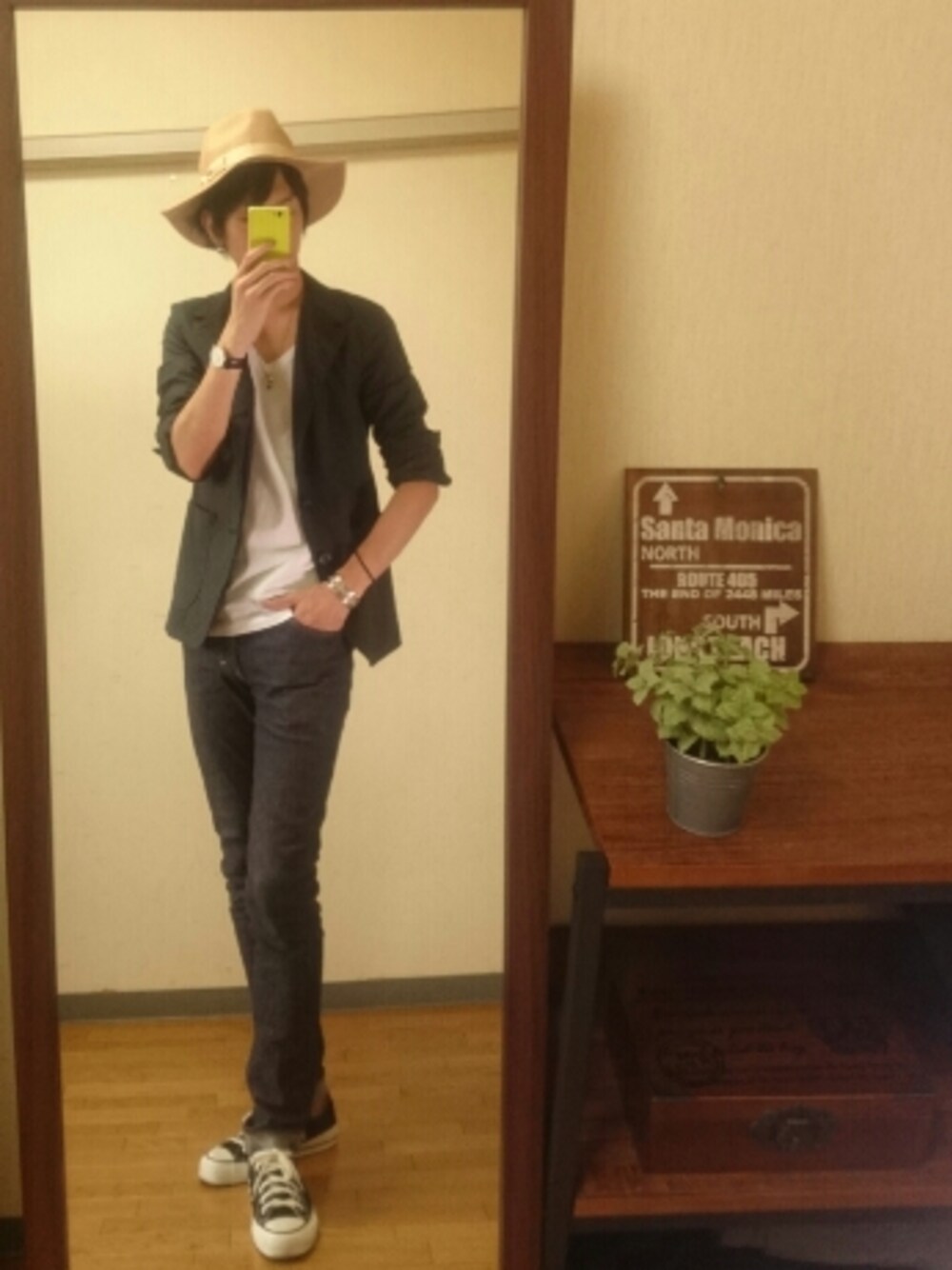 ホワイト系のTシャツ/カットソー、ブルー系のデニムパンツ、ブラック系のスニーカーを着用したメンズの秋コーディネートの1枚目の写真