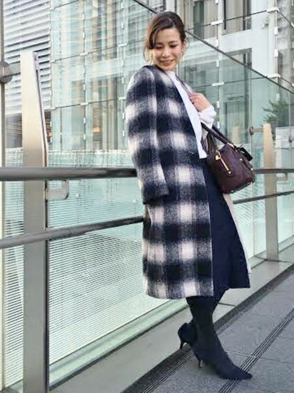 ブルー系のその他アウター、ホワイト系のニット/セーター、ブルー系のデニムスカートを着用したレディースの冬コーディネートの1枚目の写真