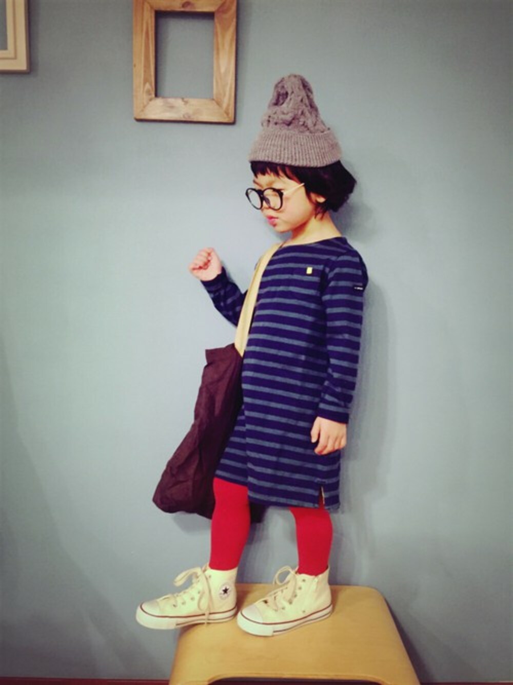 グリーン系のワンピース、ブラウン系のトートバッグ、ホワイト系のスニーカーを着用したキッズの冬コーディネートの1枚目の写真