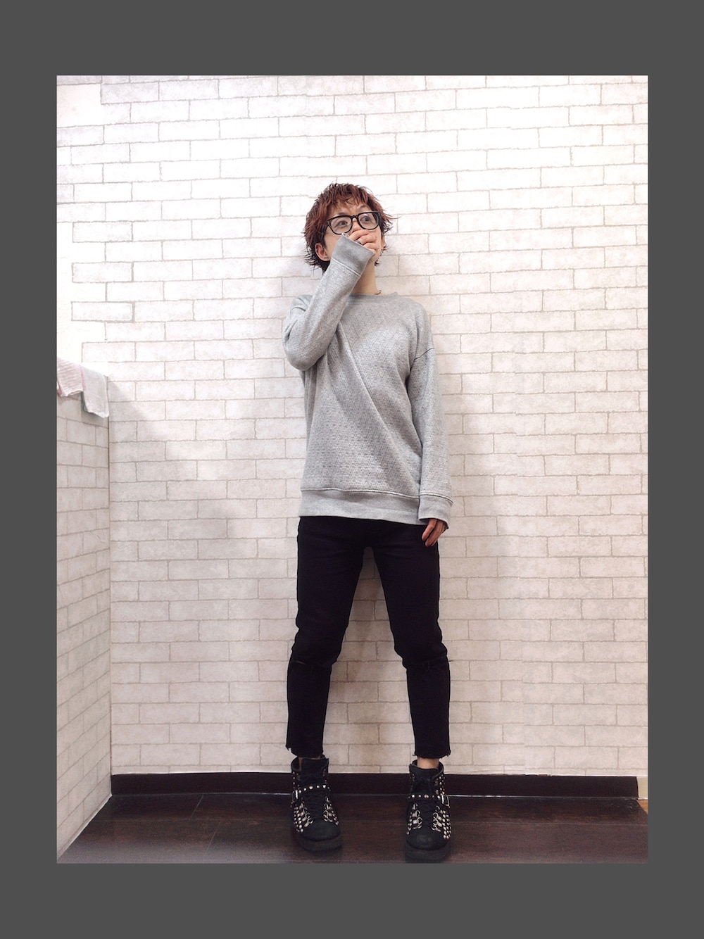 グレー系のスウェット、ブラック系のデニムパンツ、ブラック系のブーツを着用したメンズの秋コーディネートの1枚目の写真