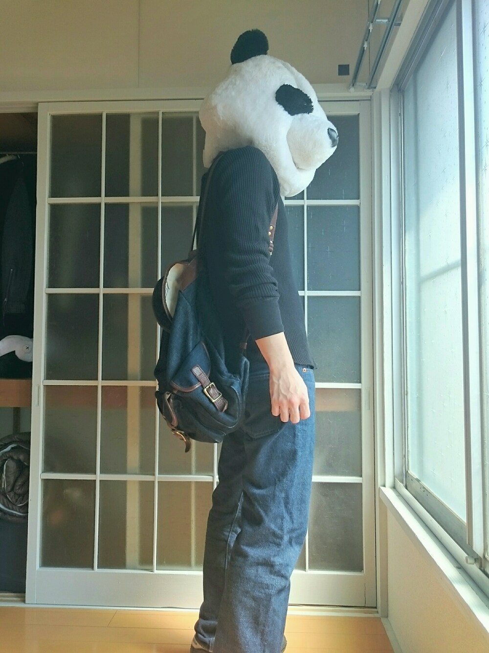 ブルー系のデニムパンツ、ブラック系のTシャツ/カットソー、ブルー系のバックパック/リュックを着用したメンズの春コーディネートの1枚目の写真