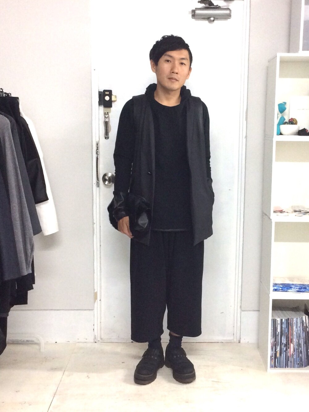 ブラック系のその他パンツ、グレー系のベスト、ブラック系のクラッチバッグを着用したメンズの秋コーディネートの1枚目の写真