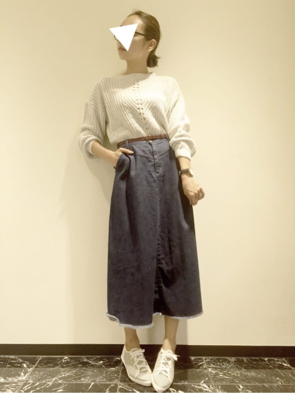 グレー系のニット/セーター、ブルー系のデニムスカート、ホワイト系のスニーカーを着用したレディースの秋コーディネートの1枚目の写真