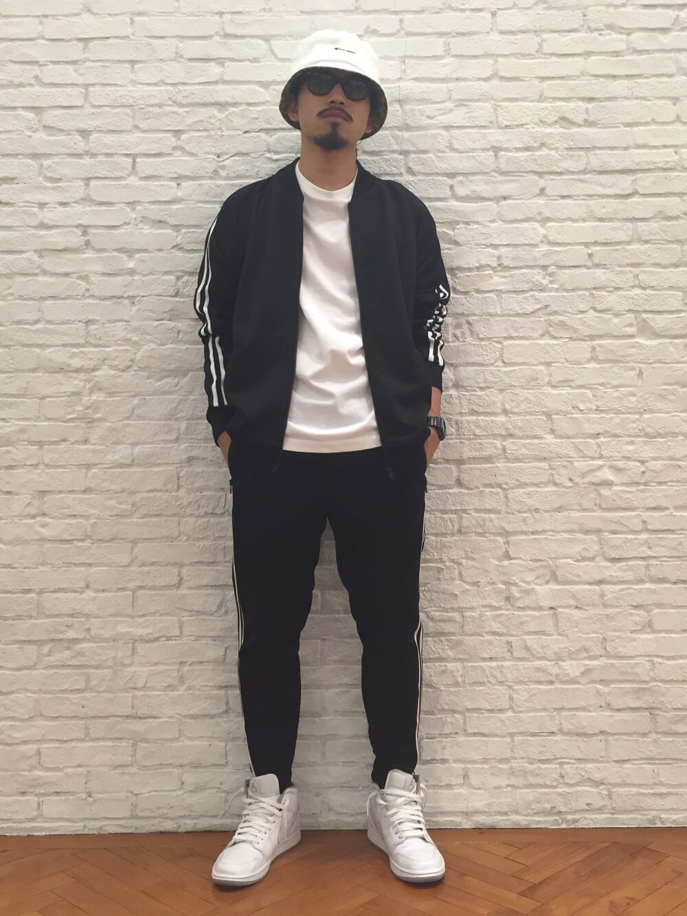 「シンプル、シンプルコーデ、モノトーン、ストリート、黒、バケットハット、ホワイト、スニーカー、春、春コーデ」｜「BASECONTROLのライントラックジャージブルゾンカーディガンジャージ（ジャージ、ブラック系）」を使った、BASECONTROL STAFFさん（メンズ・175cm）の冬コーディネートの1枚目の写真