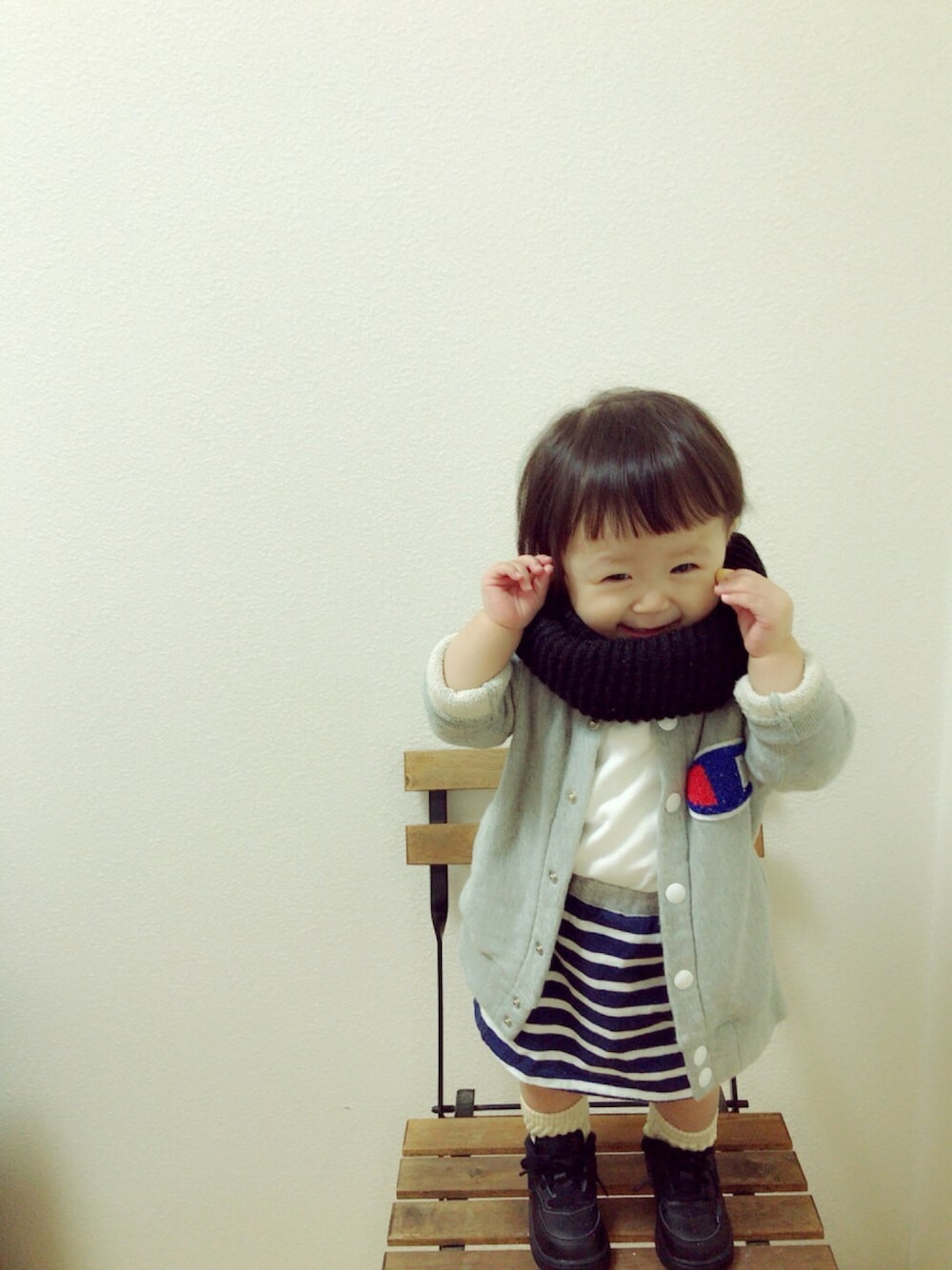 グレー系のスタジャン、ブルー系のスカート、ブラック系のスニーカーを着用したキッズの秋コーディネートの1枚目の写真