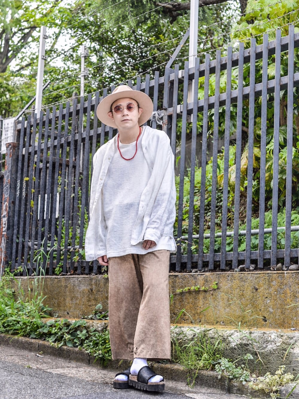 ホワイト系のシャツ/ブラウス、ホワイト系のTシャツ/カットソー、ベージュ系のスラックスを着用したメンズの春コーディネートの1枚目の写真