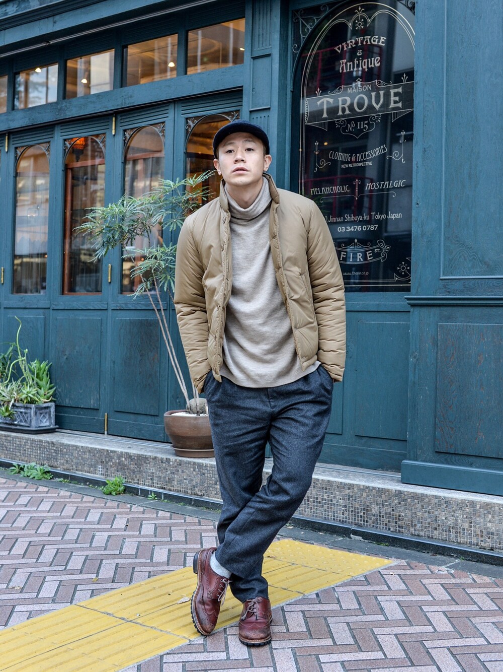 ベージュ系のダウンジャケット/コート、グレー系のその他パンツ、ベージュ系のニット/セーターを着用したメンズの秋コーディネートの1枚目の写真