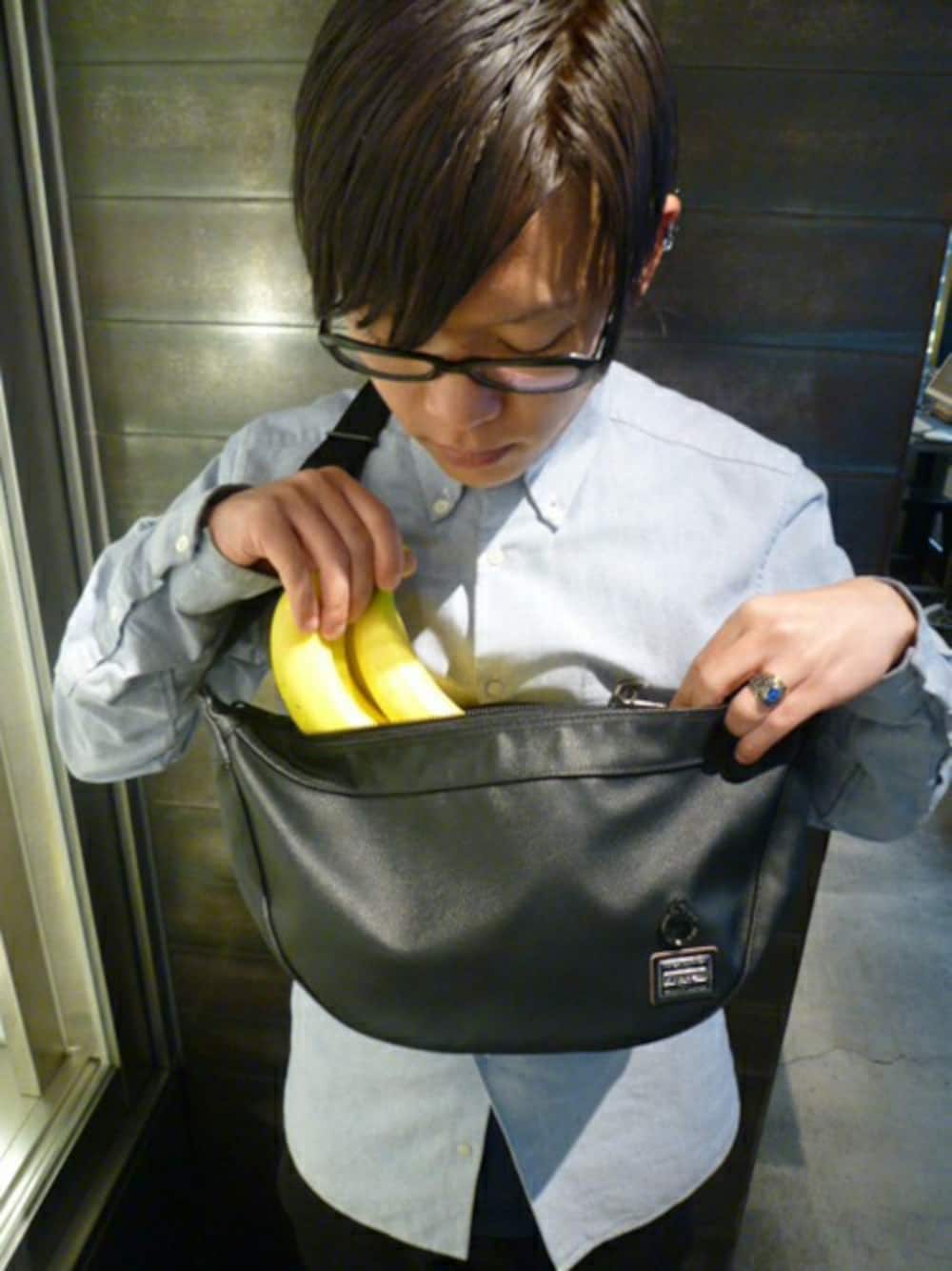 ブラック系のショルダーバッグ、ブルー系のシャツ/ブラウス、シルバー系のピアス（片耳用）を着用したメンズの冬コーディネートの1枚目の写真