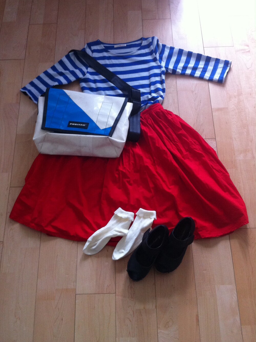 ブラック系のサンダル、レッド系のスカート、ブルー系のワンピースを着用したレディースの夏コーディネートの1枚目の写真