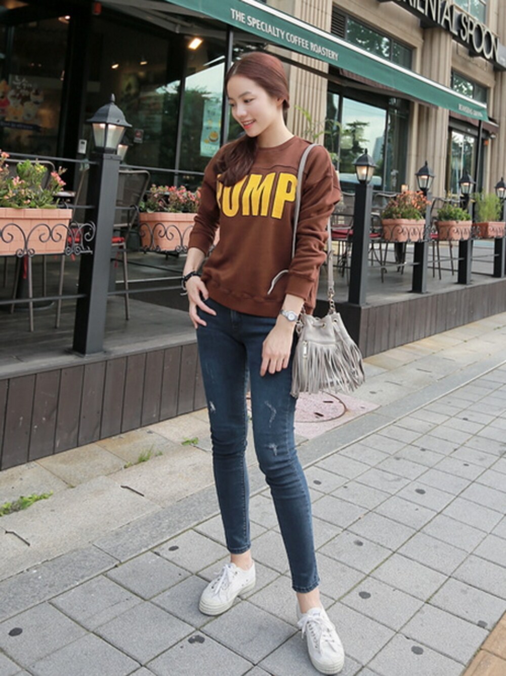 ブラウン系のTシャツ/カットソー、ブルー系のデニムパンツ、ベージュ系のショルダーバッグを着用したレディースの秋コーディネートの1枚目の写真