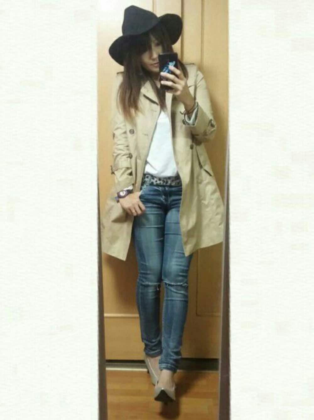 ベージュ系のトレンチコート、ブルー系のデニムパンツ、シルバー系のパンプスを着用したレディースの秋コーディネートの1枚目の写真