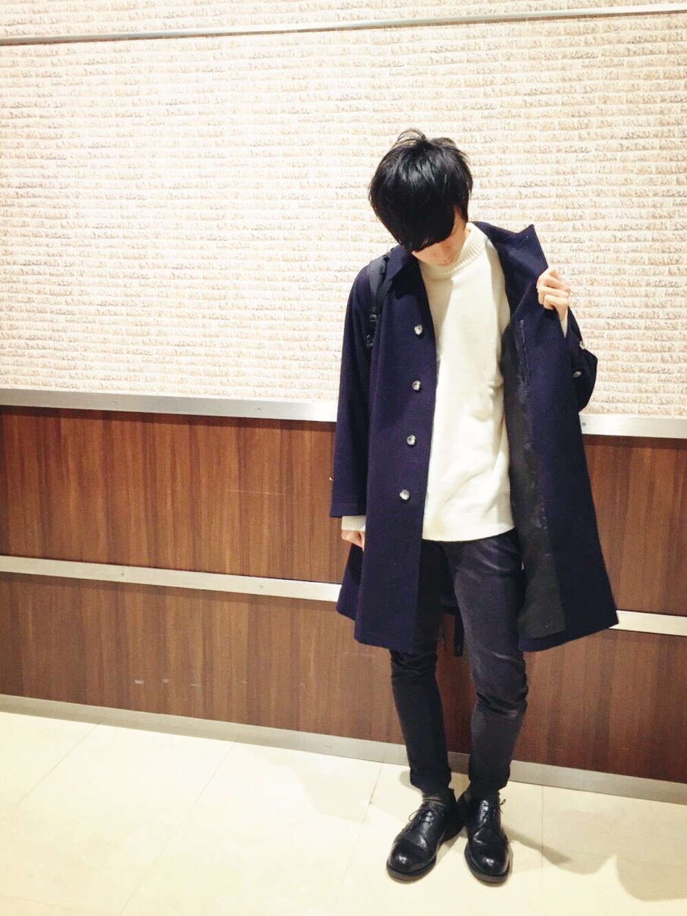 ブルー系のステンカラーコート、ホワイト系のニット/セーター、ブラック系のその他パンツを着用したメンズの冬コーディネートの1枚目の写真