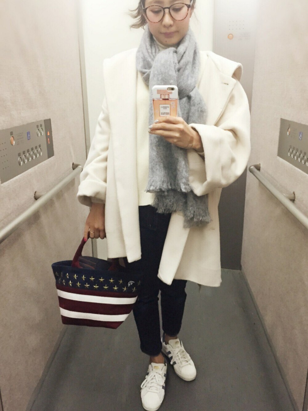 ホワイト系のステンカラーコート、ホワイト系のニット/セーター、ベージュ系のニット/セーターを着用したレディースの冬コーディネートの1枚目の写真