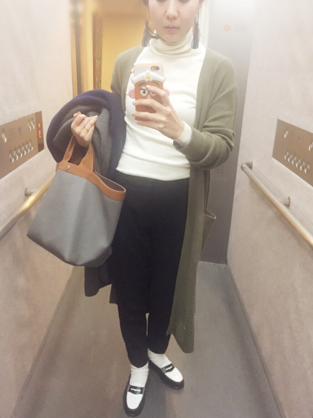 ホワイト系のニット/セーター、グリーン系のカーディガン/ボレロ、ブラック系のその他パンツを着用したレディースの冬コーディネートの1枚目の写真