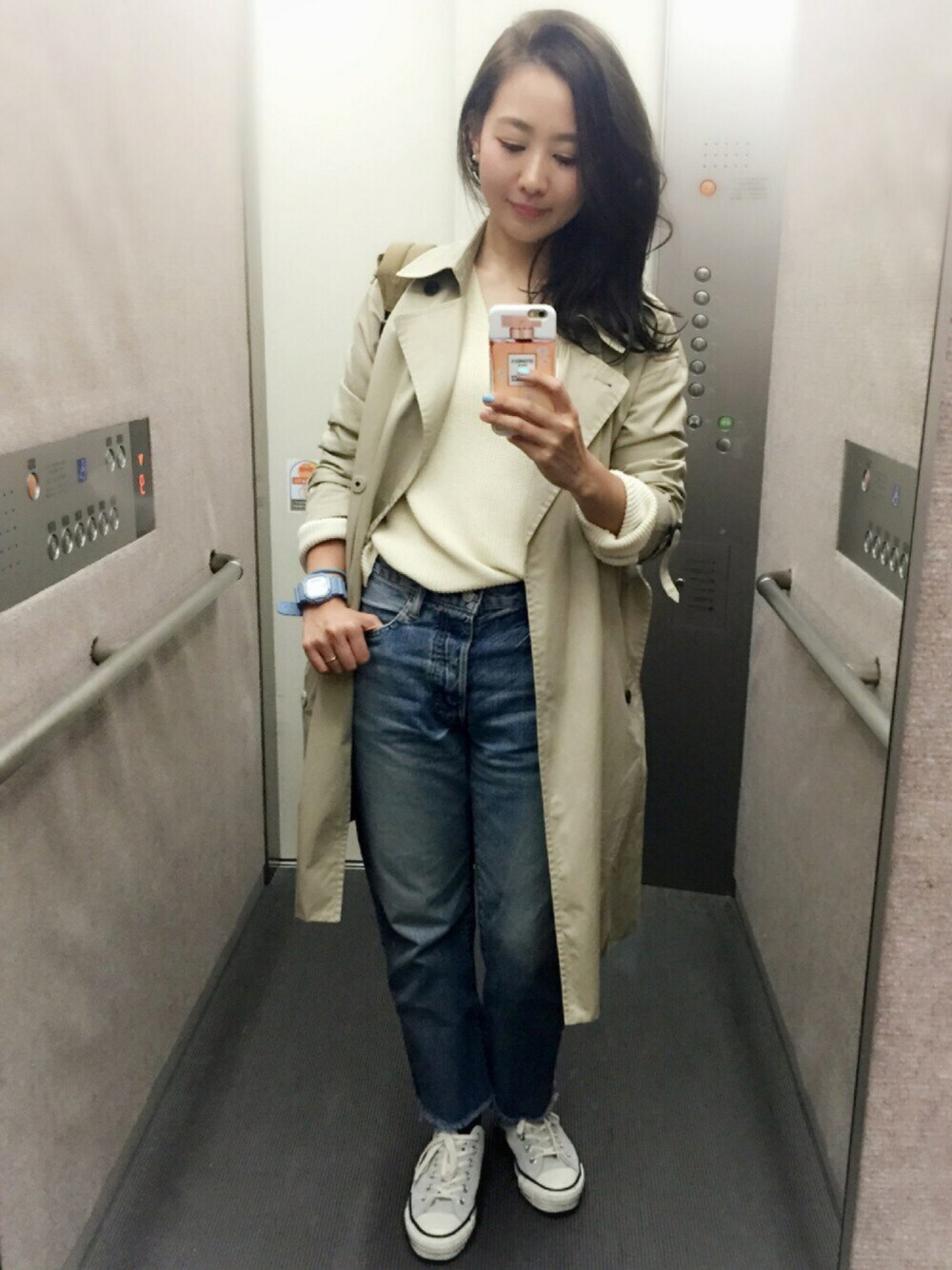 ホワイト系のニット/セーター、ブルー系のデニムパンツ、グレー系のスニーカーを着用したレディースの春コーディネートの1枚目の写真