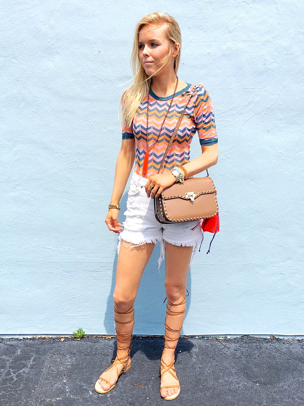 ブラウン系のショルダーバッグ、その他のTシャツ/カットソー、ブラウン系のサンダルを着用したレディースの夏コーディネートの1枚目の写真