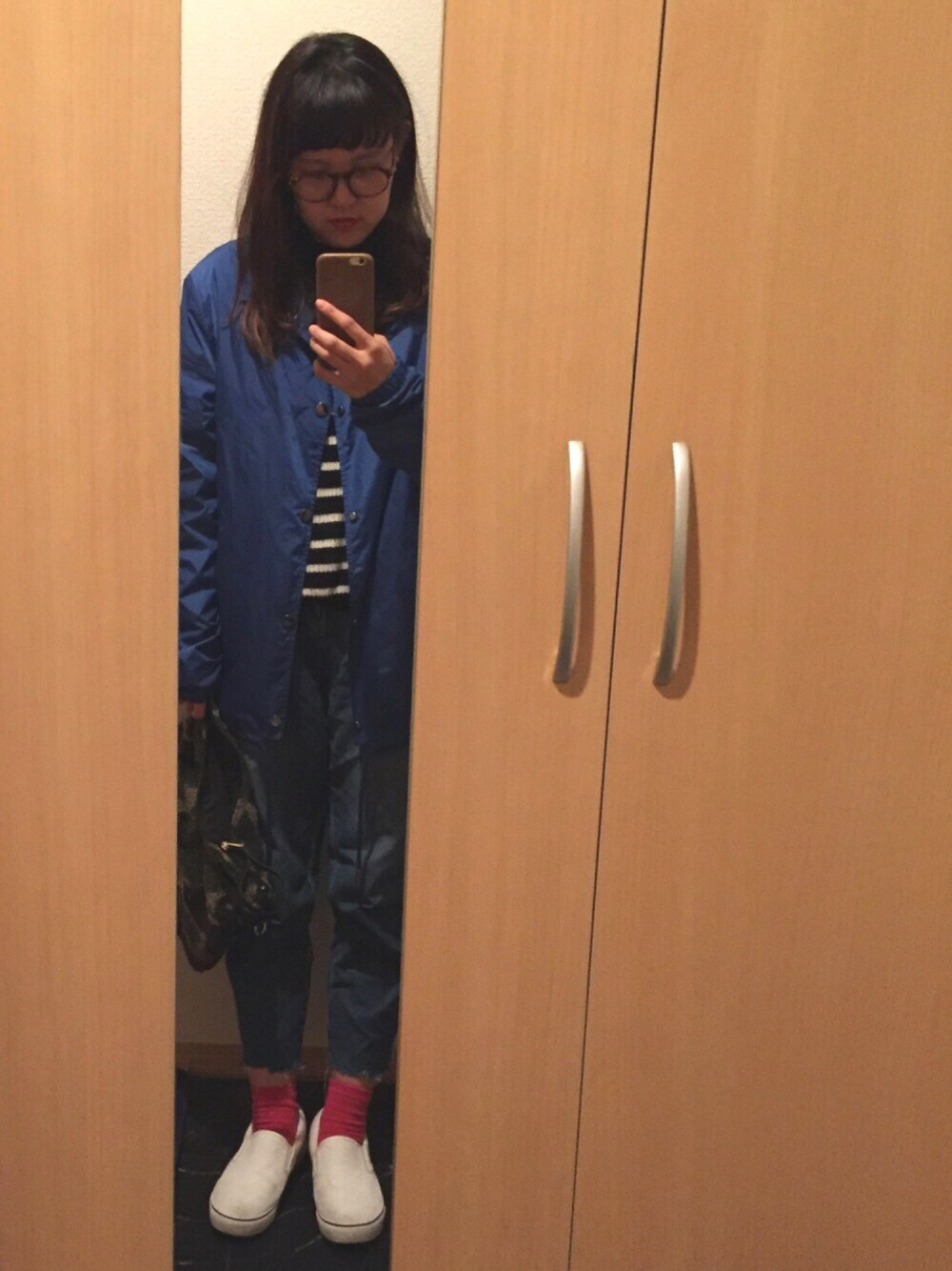 ブラック系のニット/セーター、ブルー系のナイロンジャケット、ブルー系のデニムパンツを着用したレディースの冬コーディネートの1枚目の写真