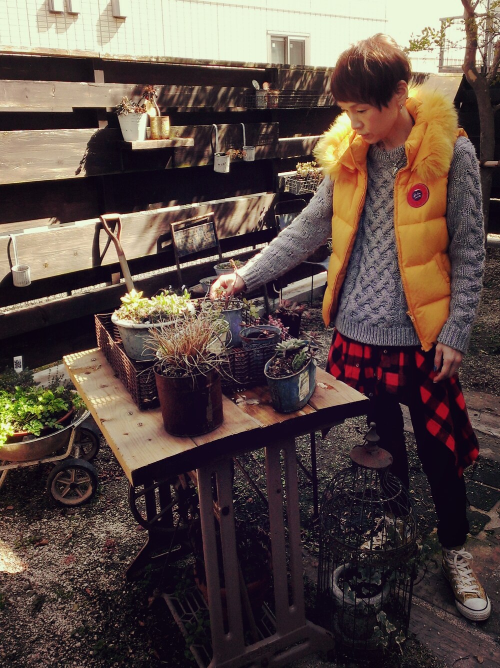 オレンジ系のダウンジャケット/コート、グレー系のニット/セーター、ブラック系のその他パンツを着用したレディースの春コーディネートの1枚目の写真