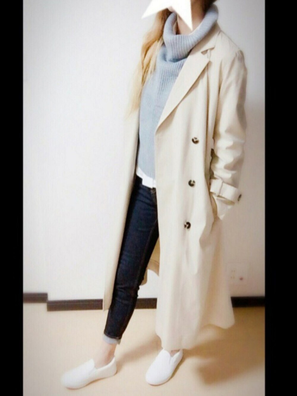 ベージュ系のトレンチコート、グレー系のニット/セーター、ブルー系のデニムパンツを着用したレディースの秋コーディネートの1枚目の写真