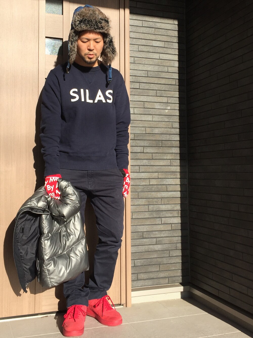 レッド系のスニーカー、その他のパンツ、シルバー系のベストを着用したメンズの冬コーディネートの1枚目の写真