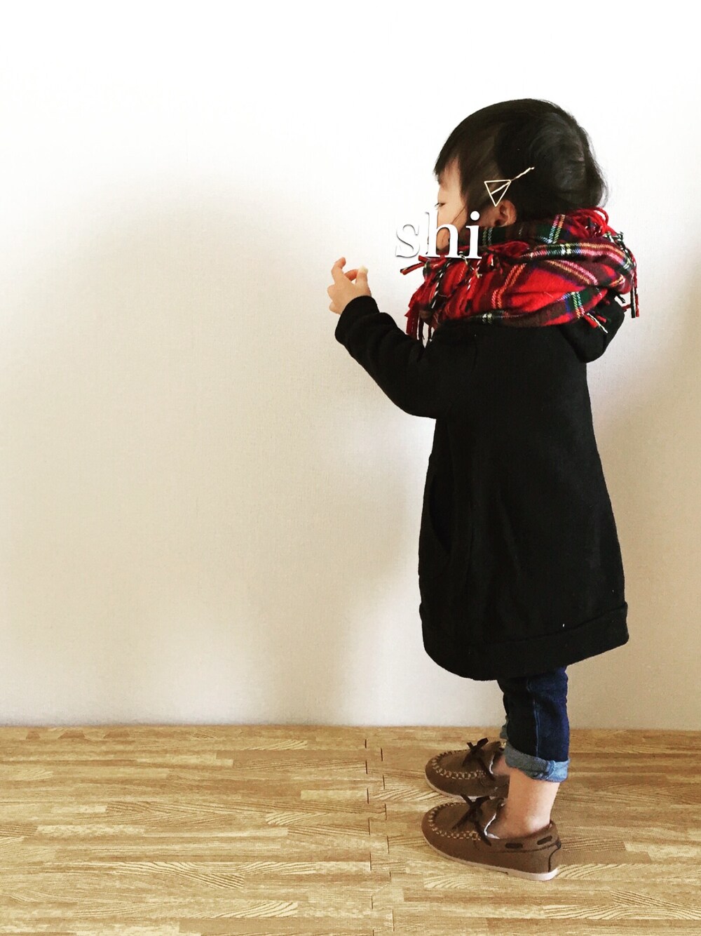 ブラック系のワンピース、ブルー系のデニムパンツ、レッド系のマフラーを着用したキッズの冬コーディネートの1枚目の写真