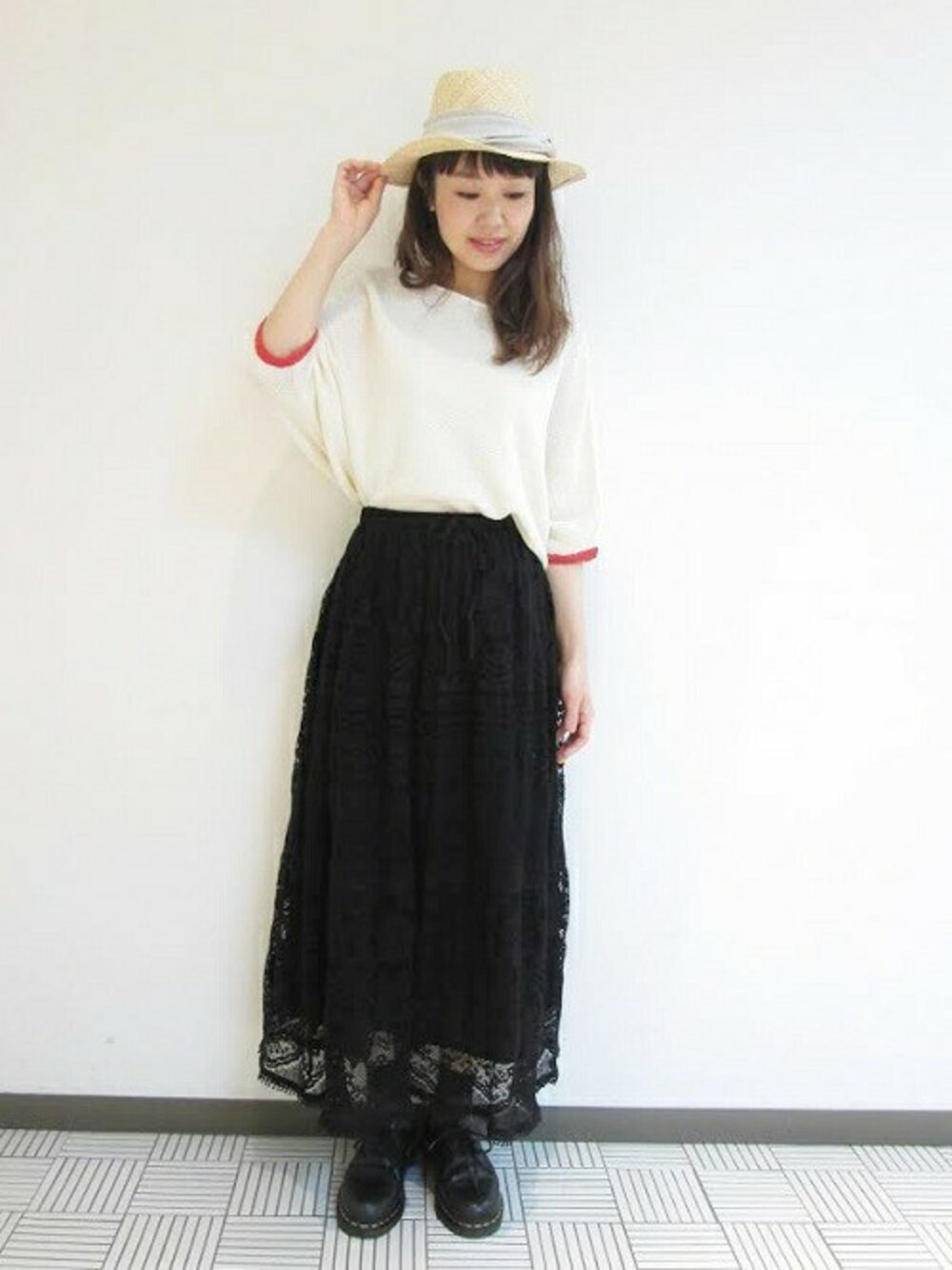 ホワイト系のニット/セーター、ブラック系のスカート、ベージュ系のハットを着用したレディースの春コーディネートの1枚目の写真