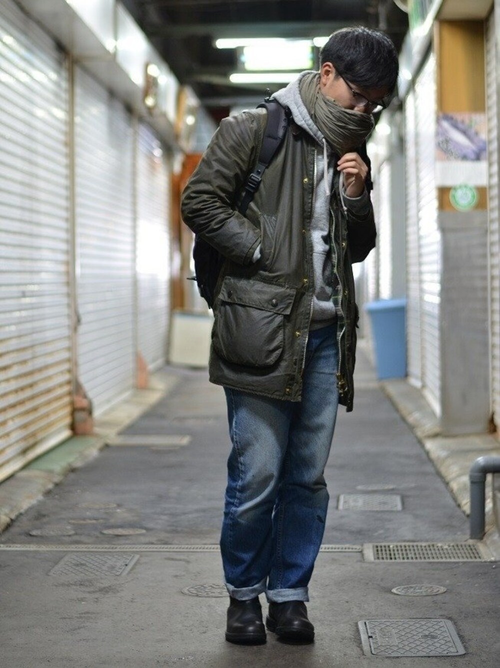 グリーン系のレインシューズを着用したメンズの春コーディネートの1枚目の写真