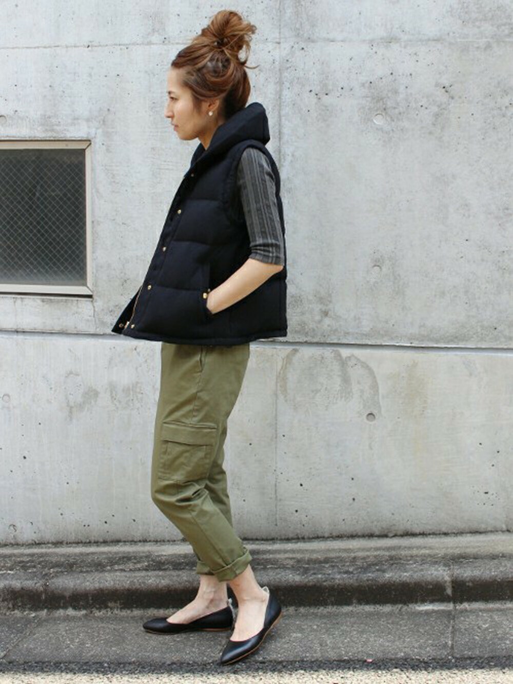 ブラック系のダウンベスト、グリーン系のカーゴパンツを着用したレディースの夏コーディネートの1枚目の写真