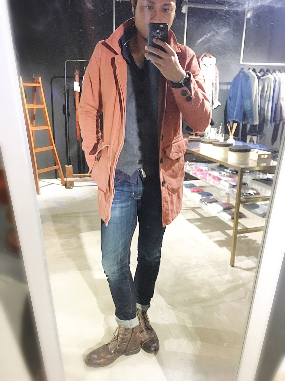 レッド系のトレンチコート、グレー系のベスト、ブルー系のシャツ/ブラウスを着用したメンズの秋コーディネートの1枚目の写真