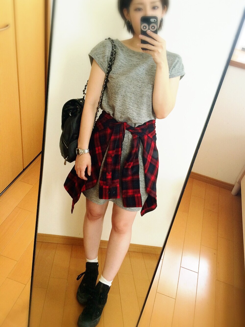 グレー系のワンピース、ブラック系のショルダーバッグ、シルバー系のピアス(両耳用)を着用したレディースの秋コーディネートの1枚目の写真