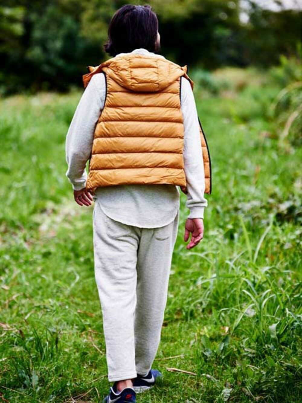 イエロー系のダウンベストを着用したメンズの冬コーディネートの1枚目の写真