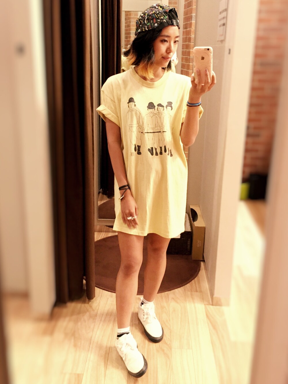 イエロー系のTシャツ/カットソー、ホワイト系のスニーカー、ブラック系のキャップを着用したレディースの夏コーディネートの1枚目の写真