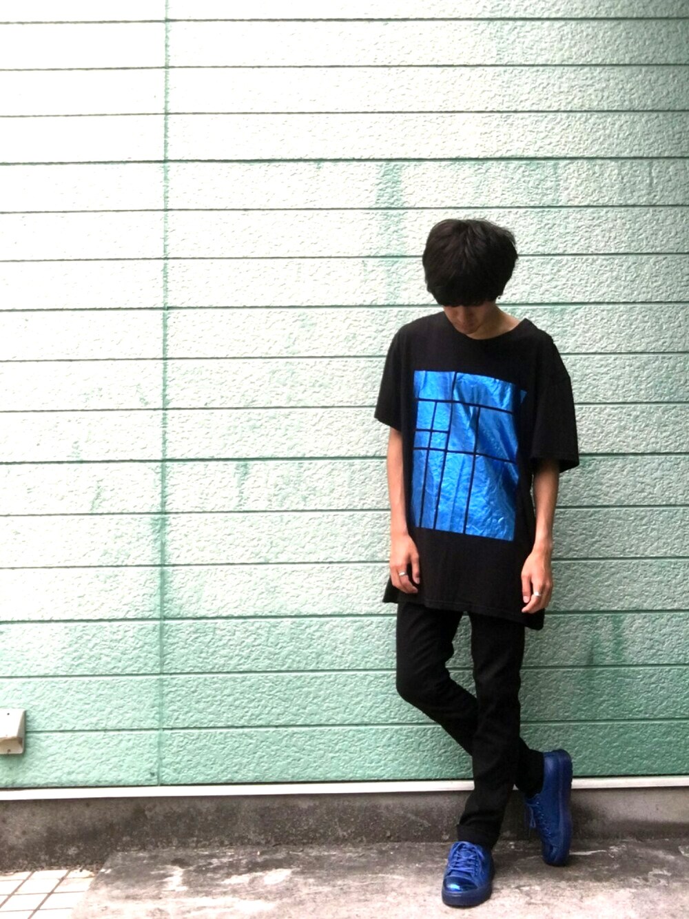 ブラック系のTシャツ/カットソー、ブルー系のクラッチバッグ、ブルー系のスニーカーを着用したメンズの夏コーディネートの1枚目の写真