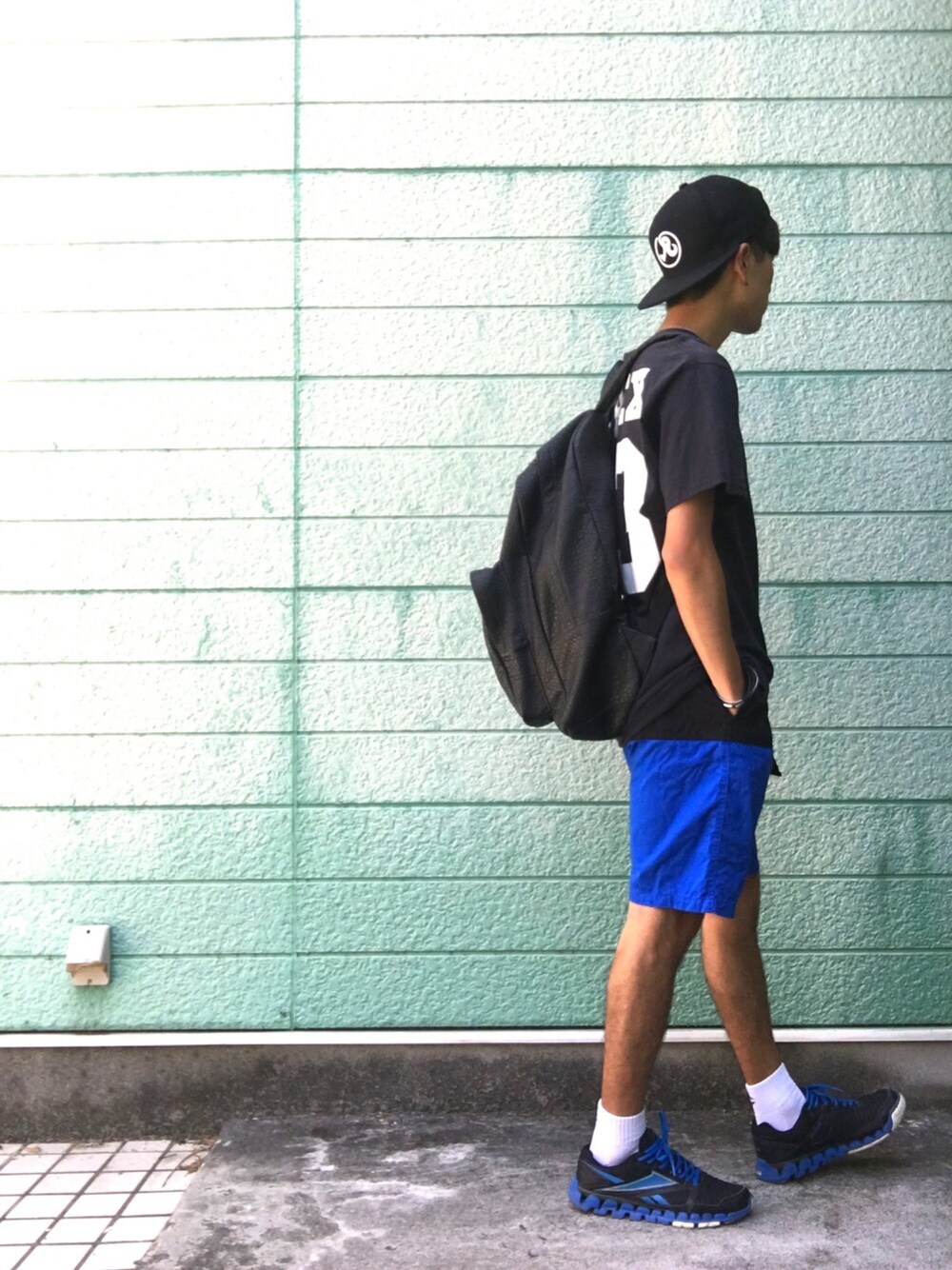 ブラック系のTシャツ/カットソー、ブラック系のバックパック/リュック、ブルー系のその他パンツを着用したメンズの夏コーディネートの1枚目の写真