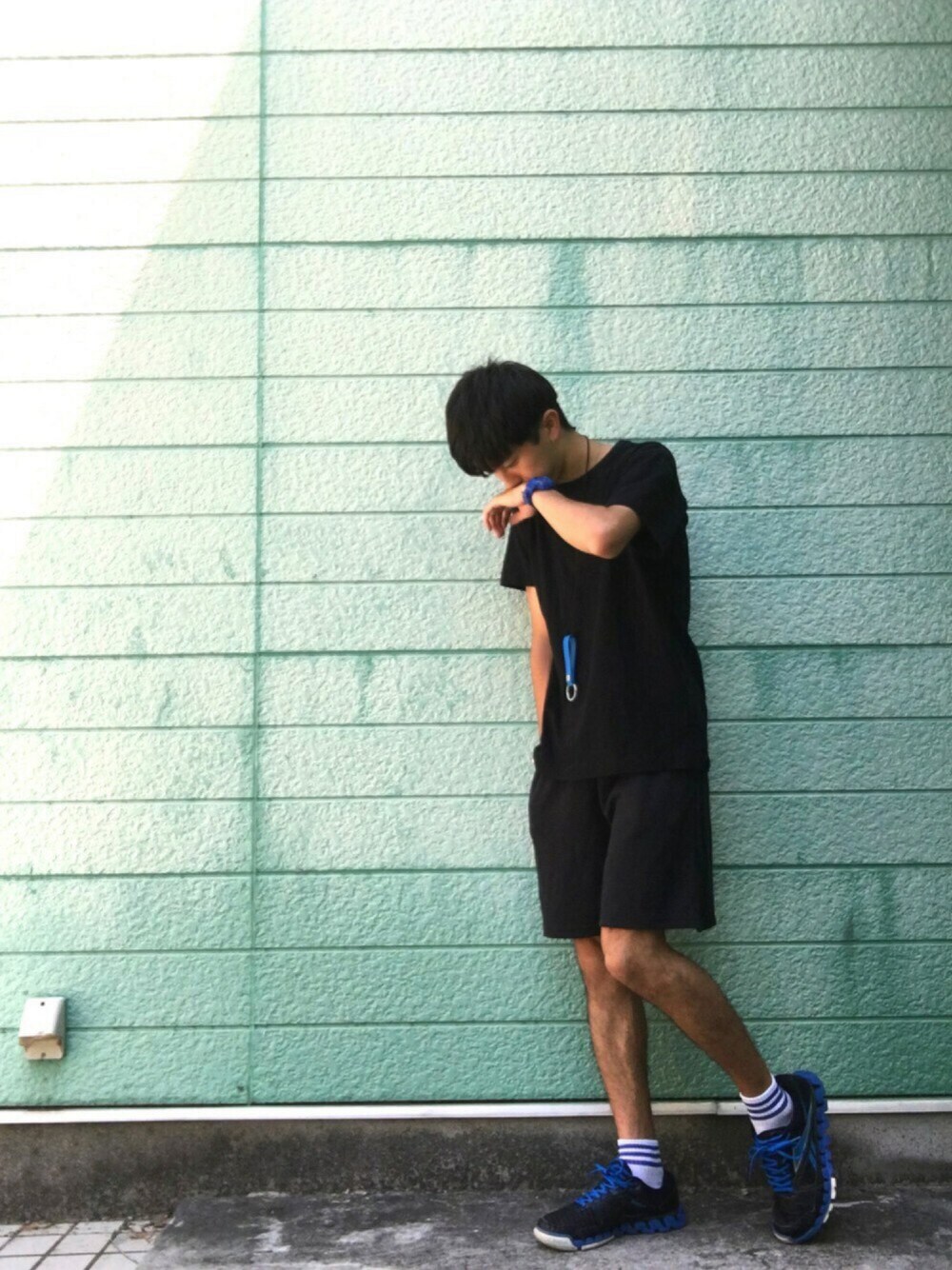 「夏コーデ、モード、スニーカー、モノトーン、ブラック、黒、ショートパンツ、カジュアル、クラッチバッグ」｜「Marc by Marc Jacobsのアイテム（キーケース/キーアクセサリー、ブルー系）」を使った、RYONCHYさん（メンズ・169cm）の夏コーディネートの1枚目の写真