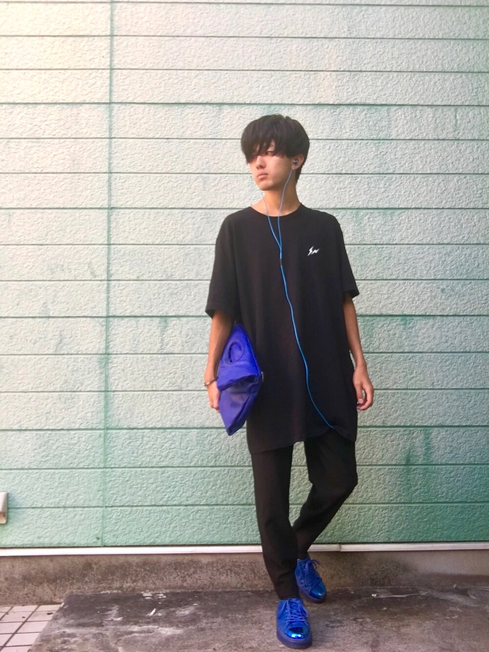 ブラック系のTシャツ/カットソー、ブルー系のクラッチバッグ、ブラック系のその他パンツを着用したメンズの秋コーディネートの1枚目の写真
