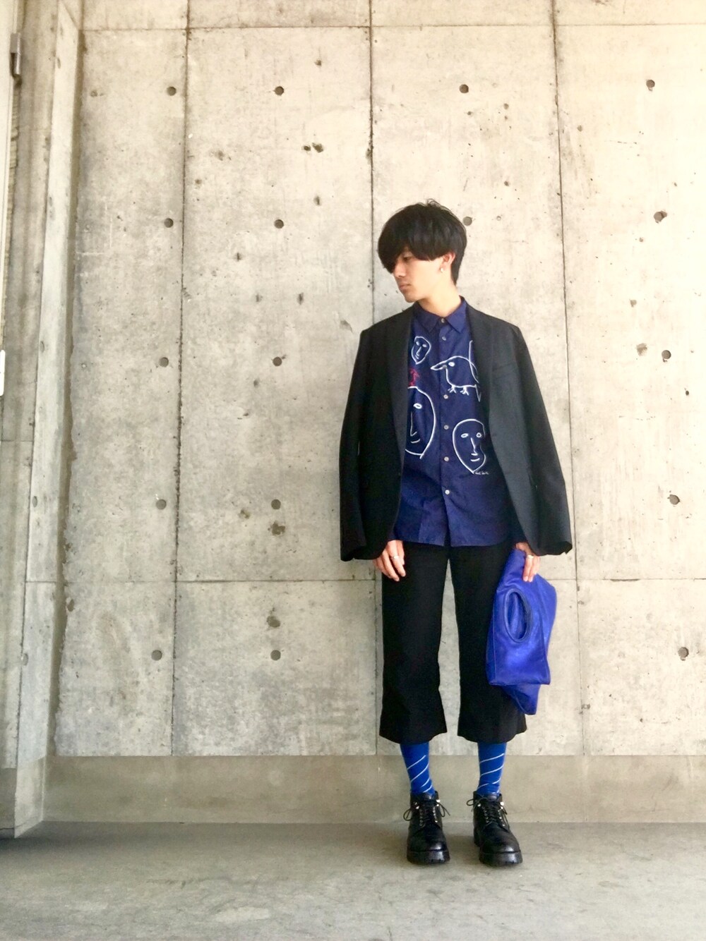 ブルー系のシャツ/ブラウス、ブラック系のテーラードジャケット、ブルー系のクラッチバッグを着用したメンズの秋コーディネートの1枚目の写真