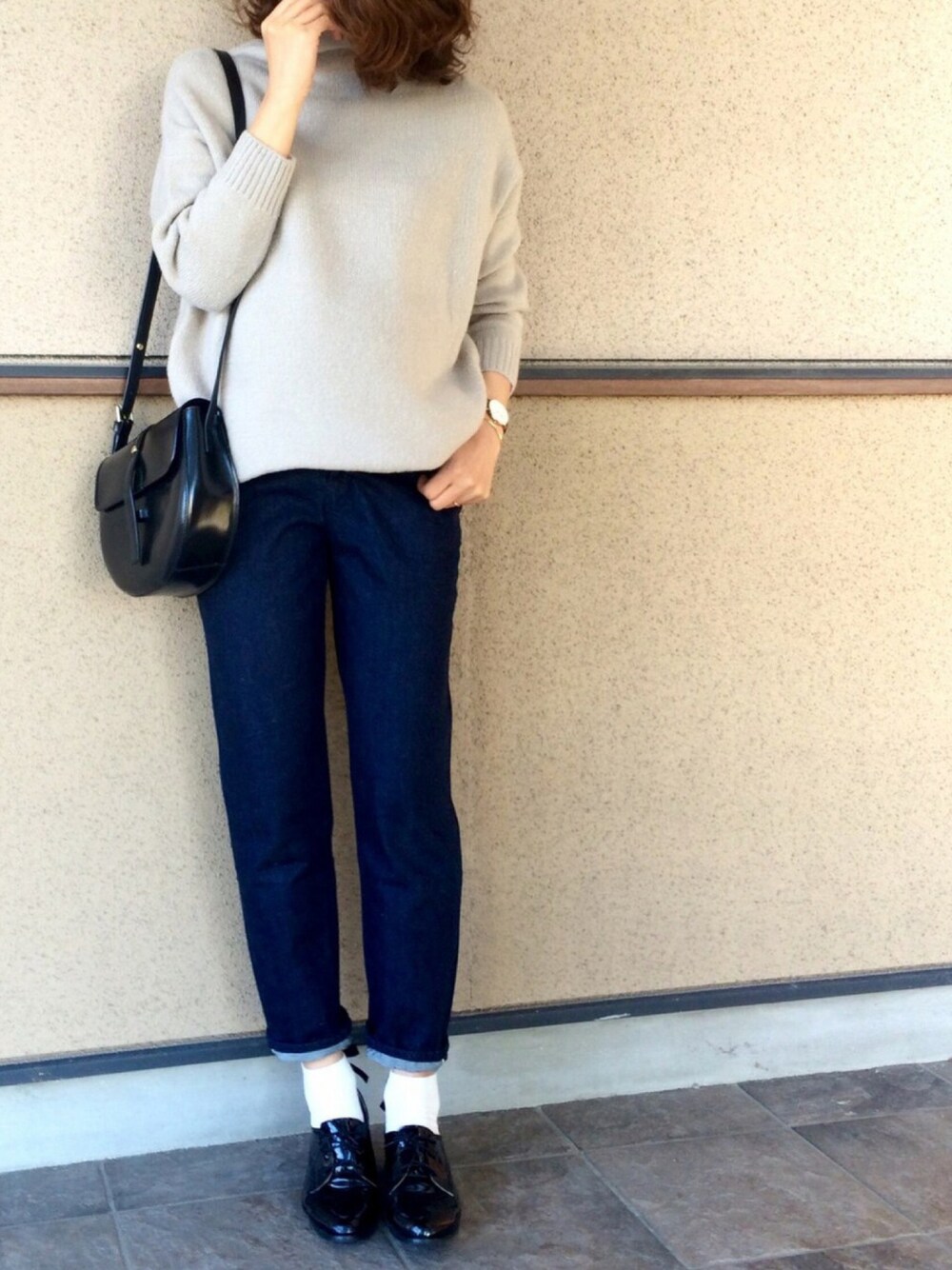 ブルー系のデニムパンツ、ブラック系のパンプス、ブラック系のハンドバッグを着用したレディースの冬コーディネートの1枚目の写真