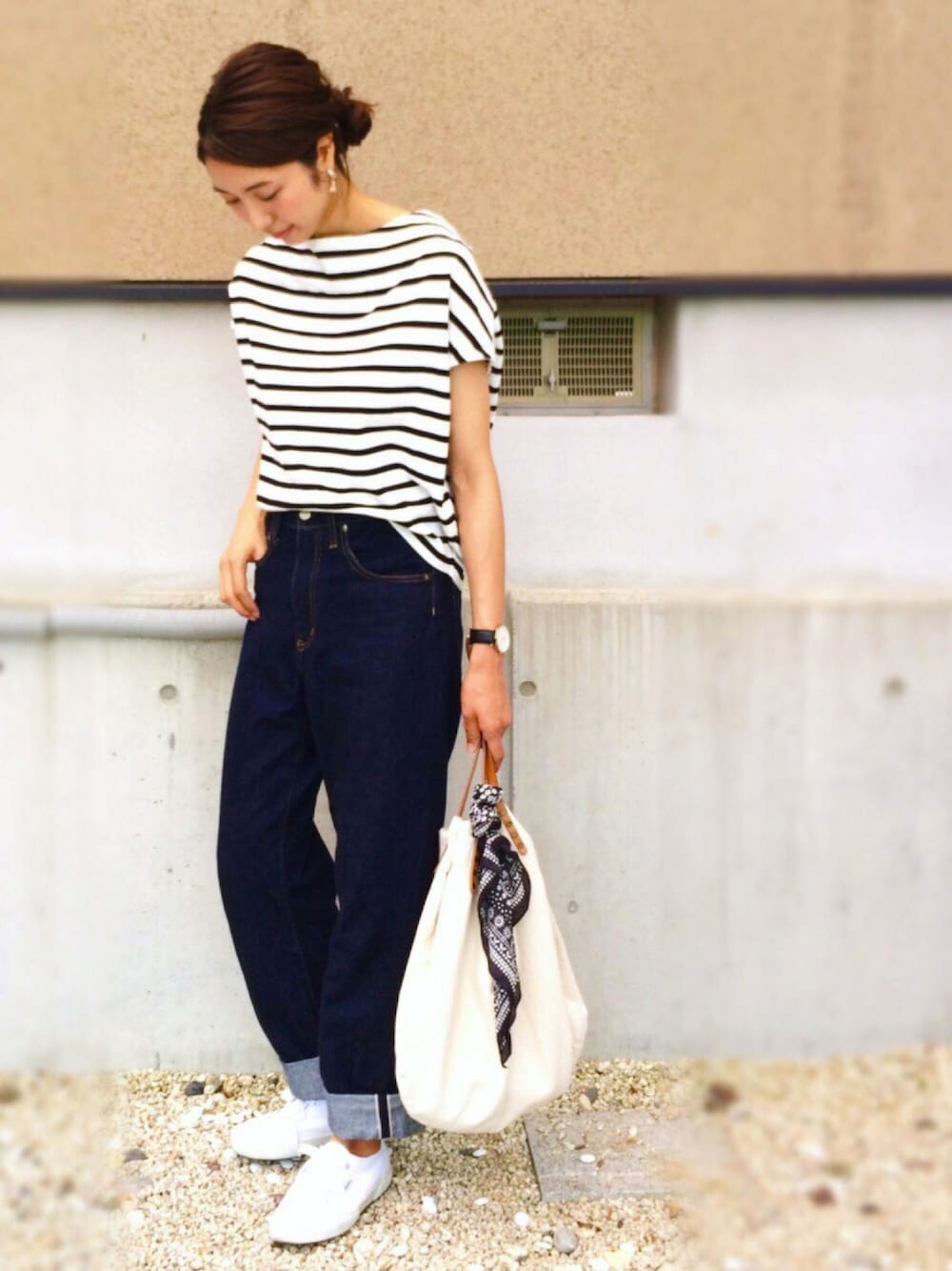 ブルー系のデニムパンツ、ホワイト系のトートバッグ、ホワイト系のスニーカーを着用したレディースの夏コーディネートの1枚目の写真