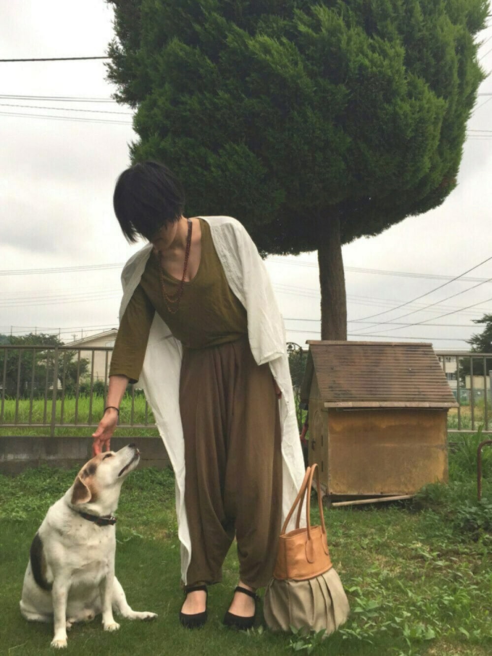 ブラウン系のバッグ、グリーン系のパンツ、ブラック系のシューズを着用したレディースの夏コーディネートの1枚目の写真