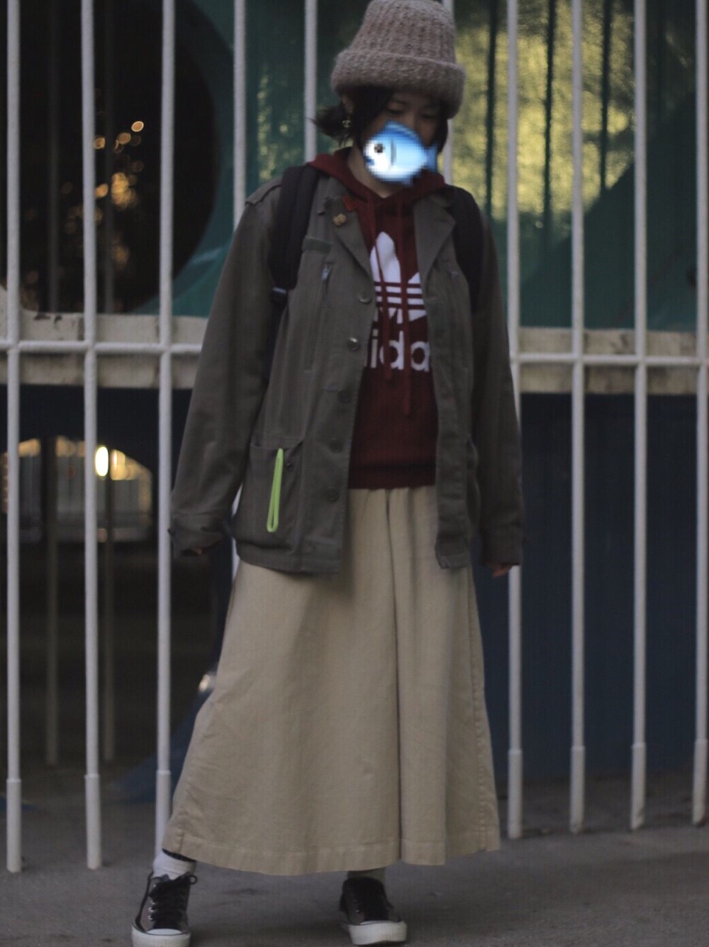 ベージュ系のスカート、レッド系のパーカー、グリーン系のミリタリージャケットを着用したレディースの秋コーディネートの1枚目の写真